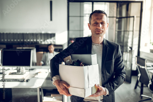 Economist leaving the office taking his box with things photo