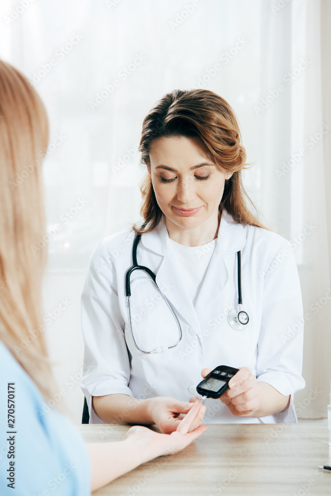 cropped view of donor and doctor measuring glucose level with glucometer cropped view of donor and doctor measuring glucose level with glucometer