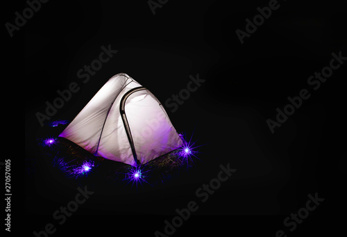 Glowing camping colorful lighting  tent in the night mountains.