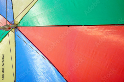 Colorful beach umbrella against sunny blue sky
