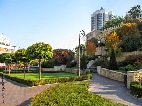 Kiev, Ukraine - October 8, 2018: Beautiful well-kept Heydar Aliyev Park in Kiev on an autumn sunny day. Neat alleys, oriental plants, well-groomed lawns, street lamps and a copy of Baku fortress wall