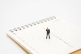 Miniature people businessmen analyze standing on a Book Rankings (list). using as background business concept with copy space and white space for your text or  design.
