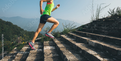 Fitness running woman trail runner on the great wall top of mountain