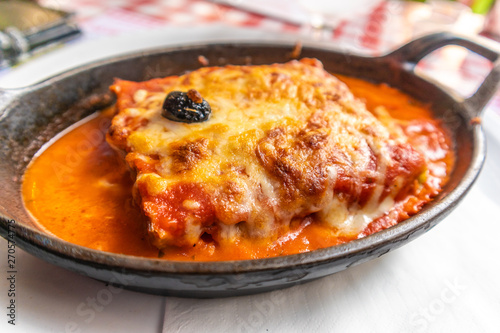 Traditional Italian lasagna with a lot of sauce in a pan