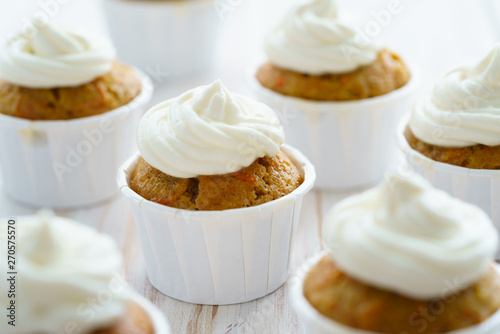 Carrot cupcakes with vanilla frosting. White wooden table, high resolution