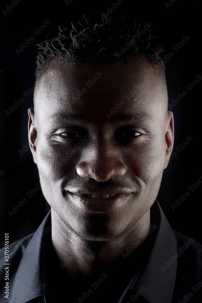 portrait of a african man on black background, smilimg