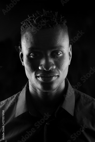 portrait of a african man on black background, serious