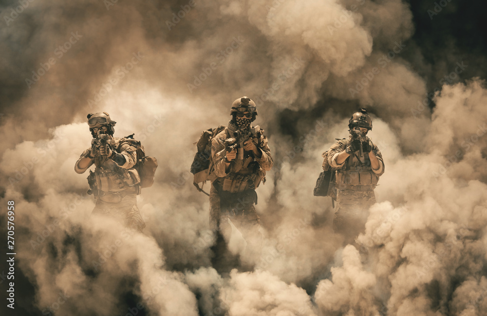 Military soldier between smoke and dust in battlefield - obrazy, fototapety, plakaty 