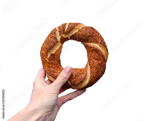 Traditional Turkish bagel simit in female hand isolated on white background photo