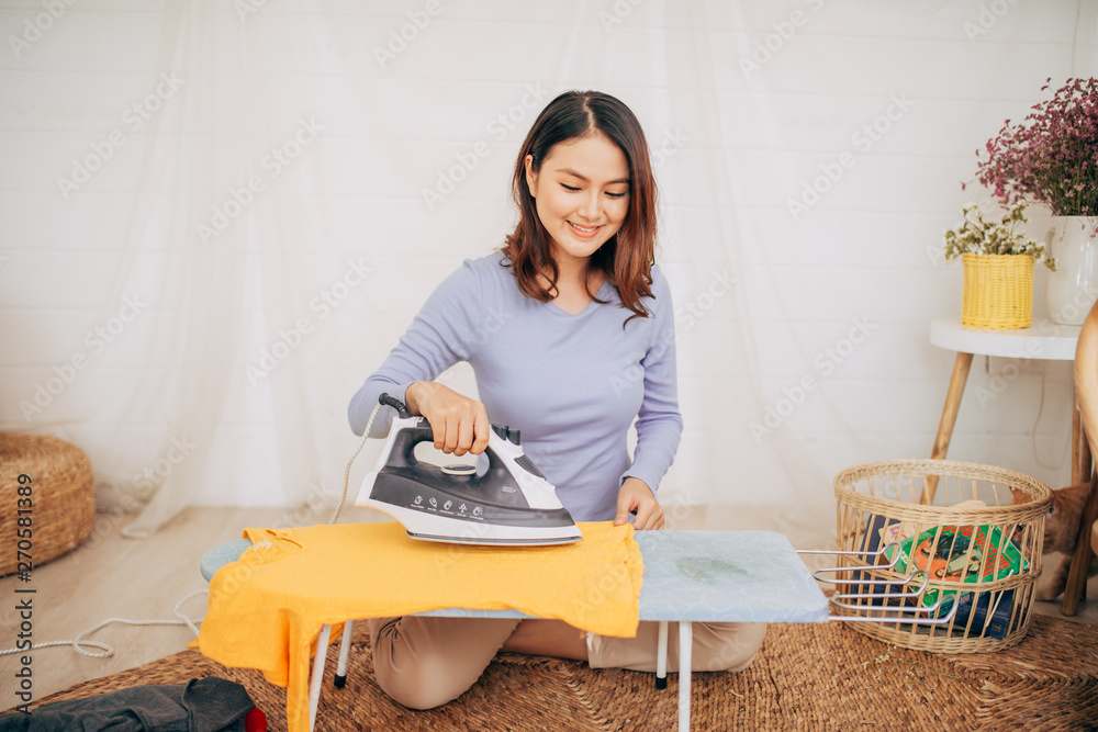 Young Smiling Woman Ironing Clothes On Ironing Board Young Smiling Woman Ironing Clothes On Ironing Board
