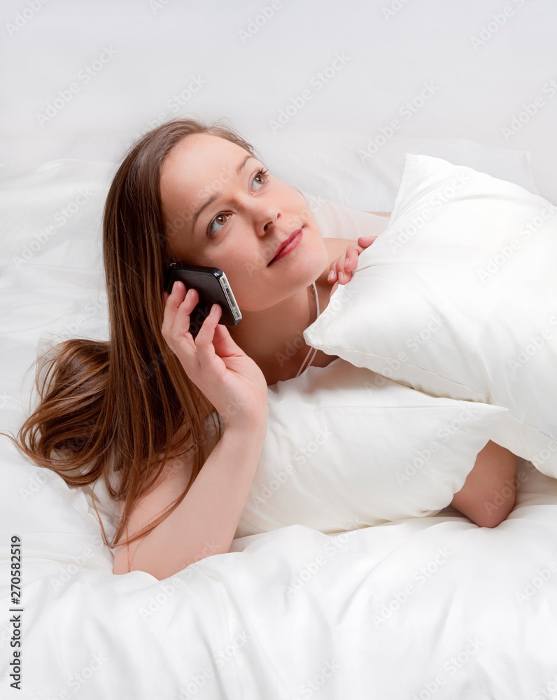 Woman in bed talking on phone. Woman in bed talking on phone.
