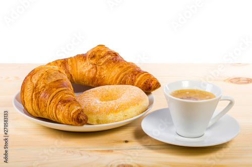 Delicious breakfast. Two croissants, a donut and a coffee on a wooden surface