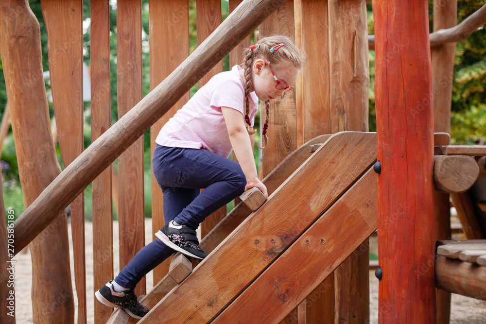 young girl in glasses goes in for sports on the playground. rest and childhood outdoors