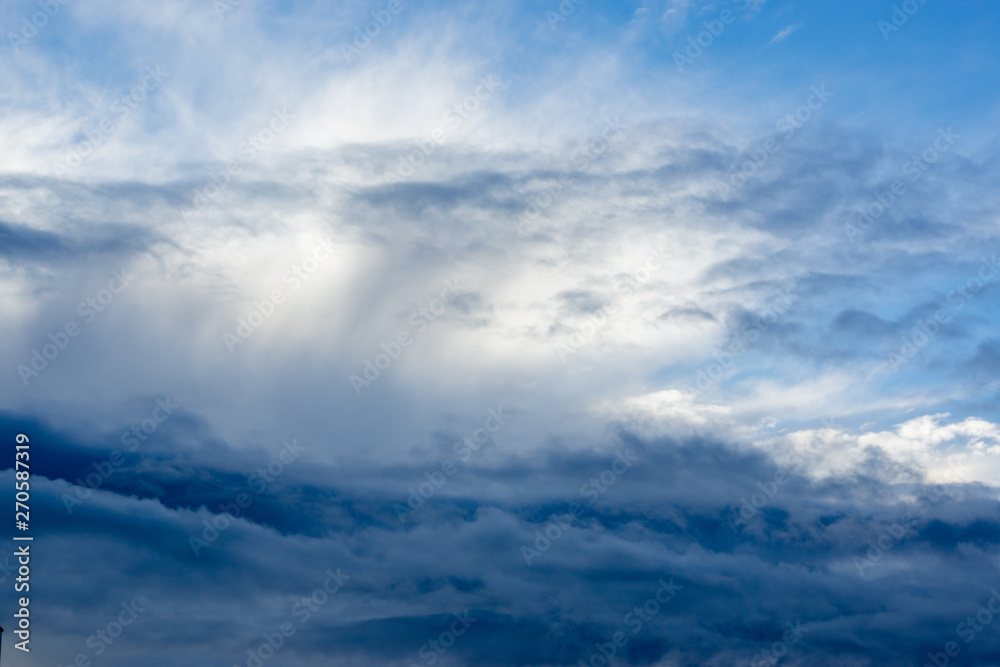 through the dark and white clouds you can see the blue sky.