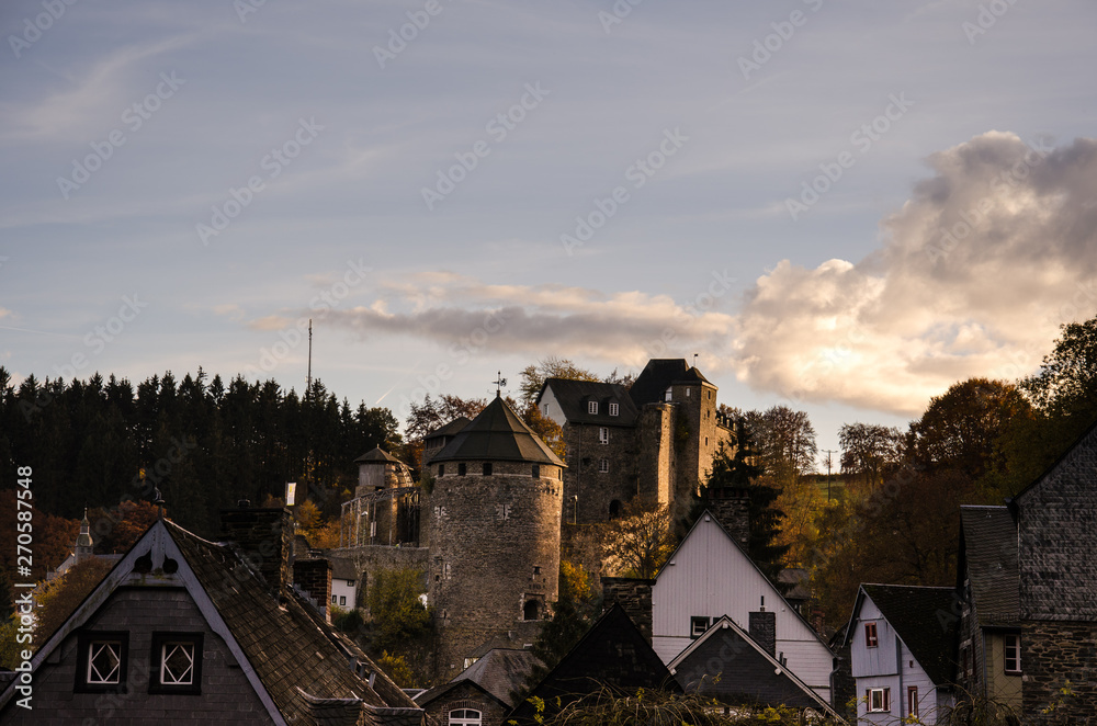 Burg Monschau, a hill castle in Monschau, Germany, above the town, at sunset