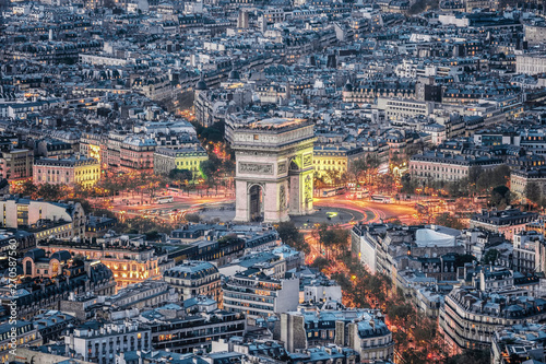 Aerial view of the Arc de Triomphe de l'Etoile (The Triumphal Arch) in Paris at sunset with traffic lights.