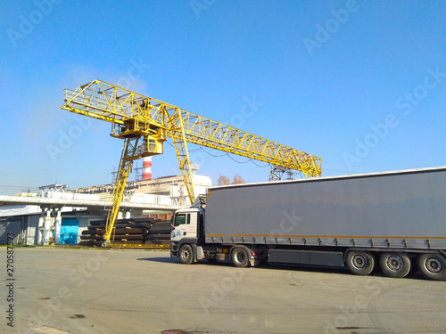 yellow gantry crane and cargo van