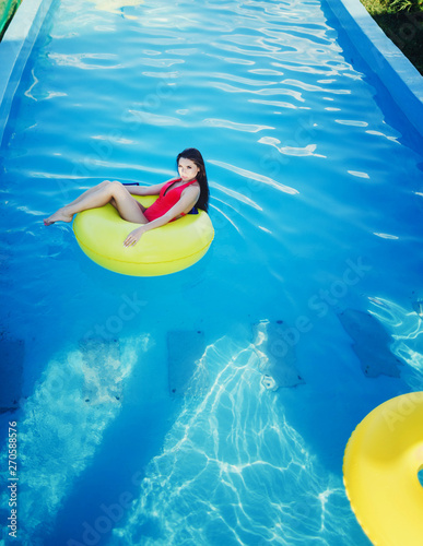 beautiful girl swimming in the pool on an inflatable circle