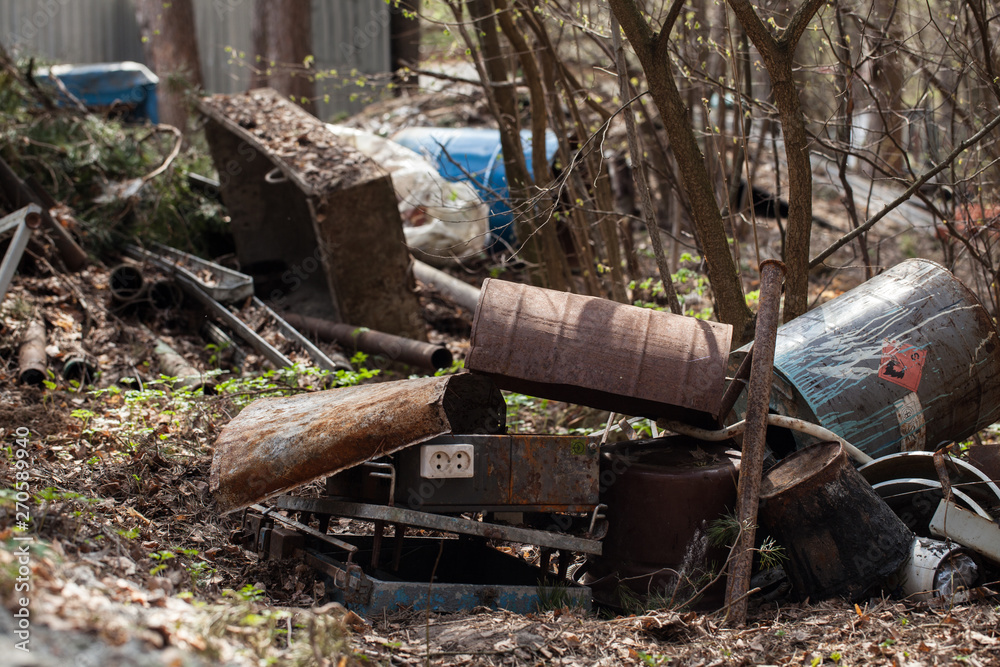 dumping rusty dirty waste in the forest. environmental hazard dumping rusty dirty waste in the forest. environmental hazard