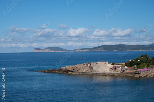 View of Capo Caccia from Alghero (L'Alguer), province of Sassari , Sardinia, Italy. Famous for the beauty of its coast and beaches and its historical city center. 