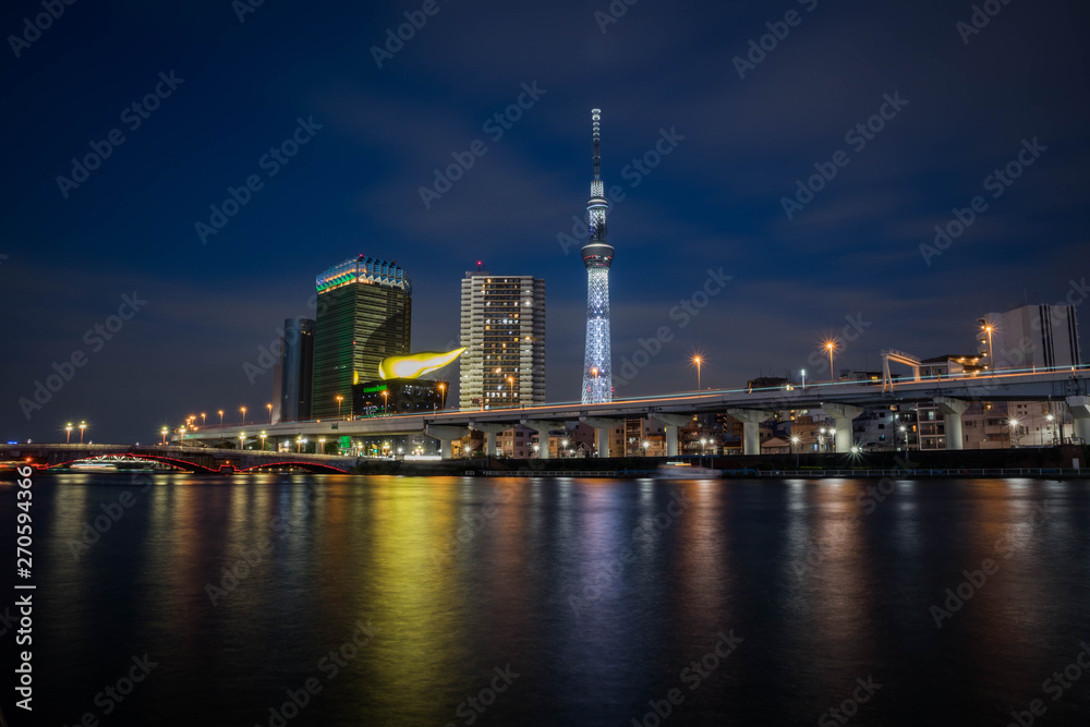 View of the Skytree Tower with the reflection in the river at night. Landscape orientation.