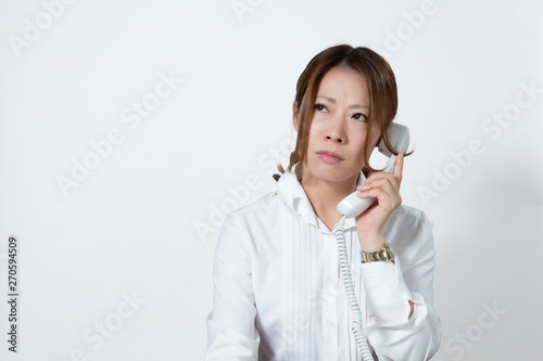 固定電話で会話する女性