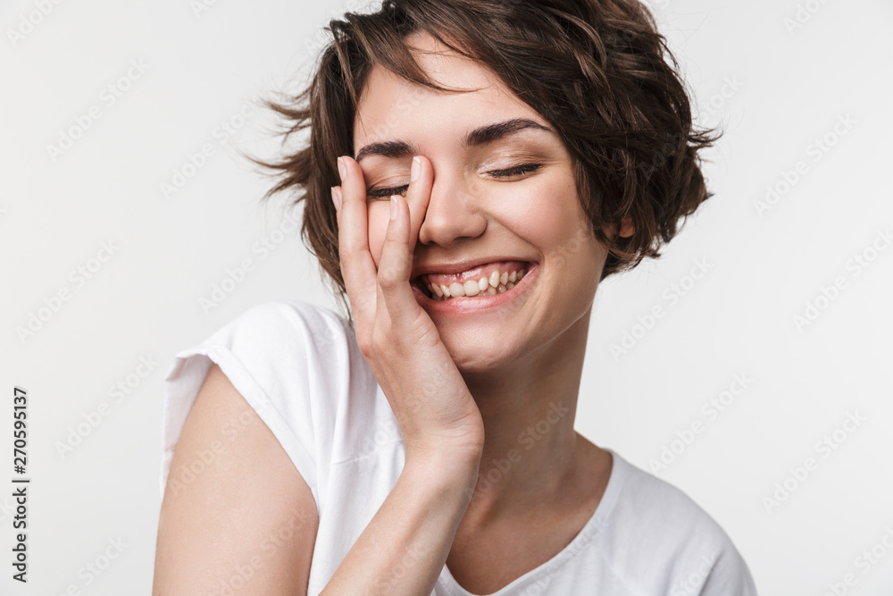 Portrait of kind woman with short brown hair in basic t-shirt smiling and touching her face with hand Portrait of kind woman with short brown hair in basic t-shirt smiling and touching her face with hand