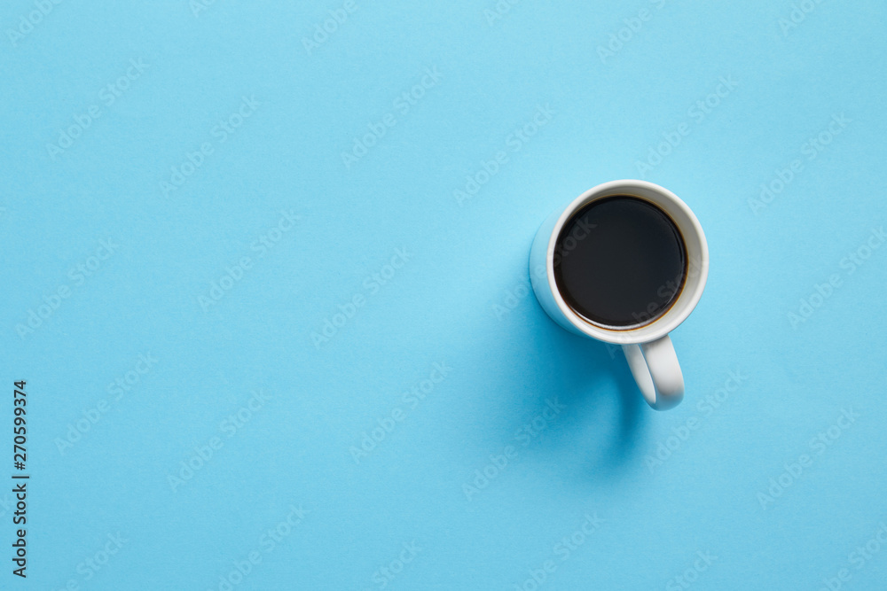 Top view of cup of hot coffee on blue background - obrazy, fototapety, plakaty 