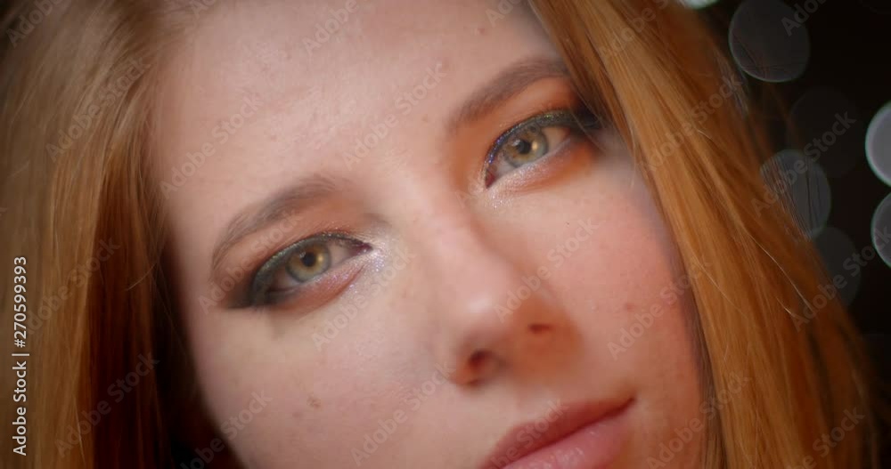 Gorgeous model with shimmering make-up watches gracefully into camera on blurred lights bokeh background. Gorgeous model with shimmering make-up watches gracefully into camera on blurred lights bokeh background.