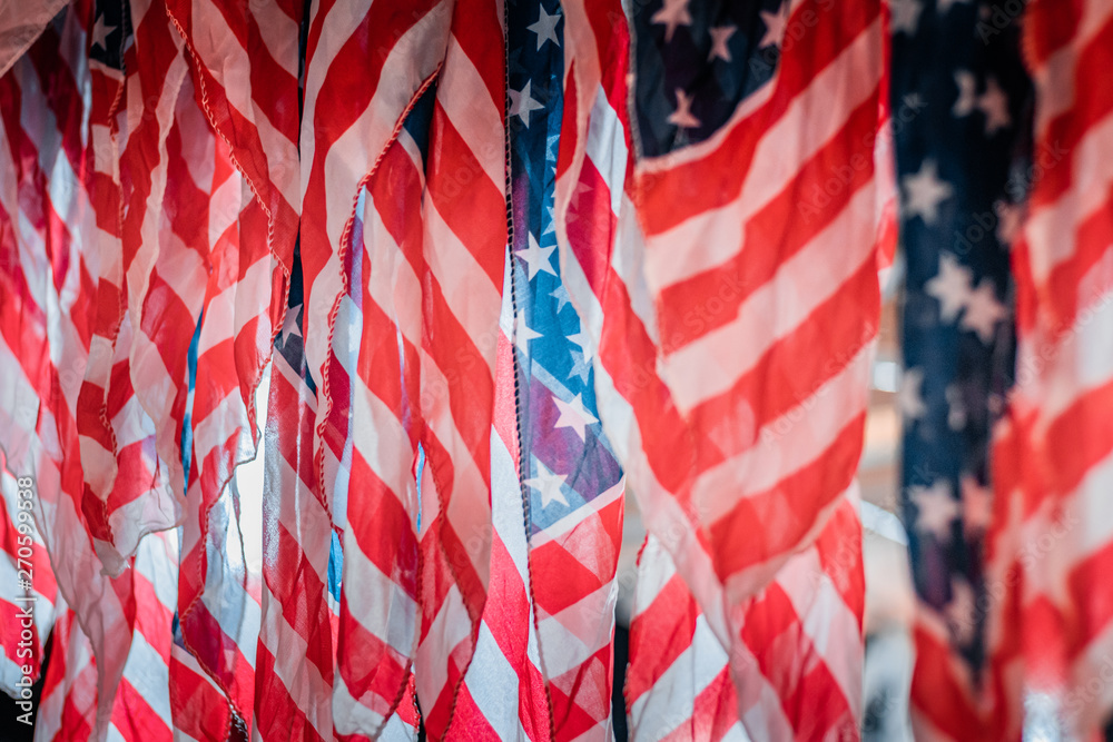 Fototapeta premium Detail and close up shot of waving american flags. Rippled red and white stripes, patriotism and national pride concept. Natural daylight, warm and cool color tones. 