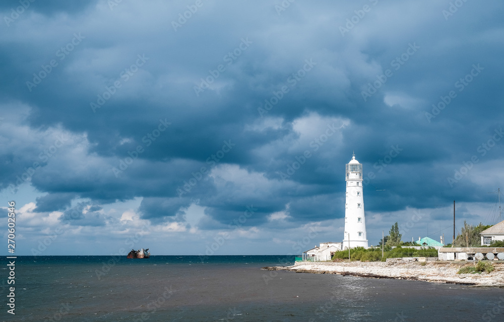 Lighthouse on the background of rain clouds
