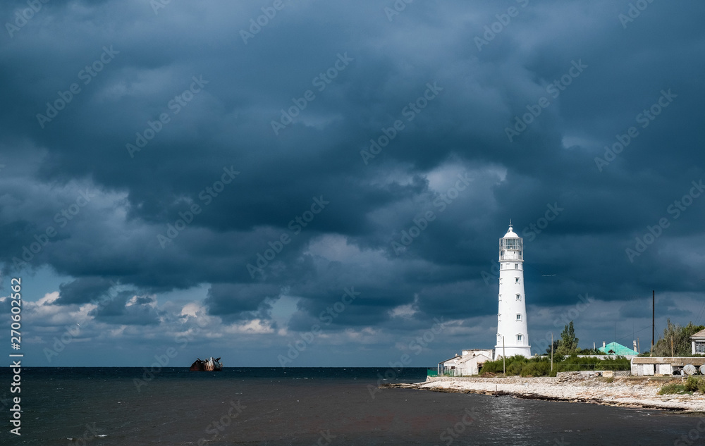 Lighthouse on the background of rain clouds