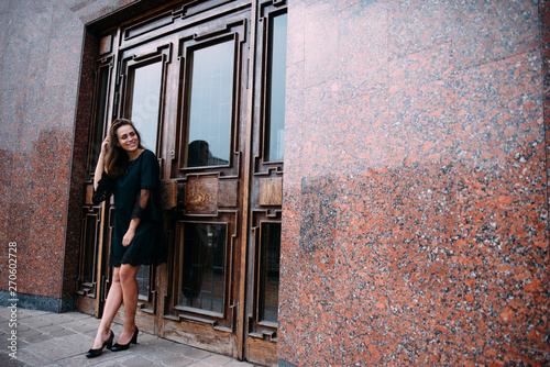 Young girl in green dress near old big building door photo