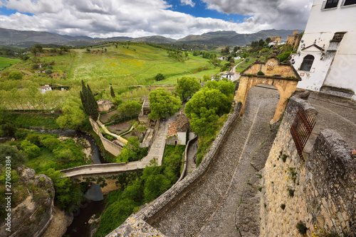 Arch of Felipe V with old Arab bridge and Arab Bath ruins in the city of Ronda Spain