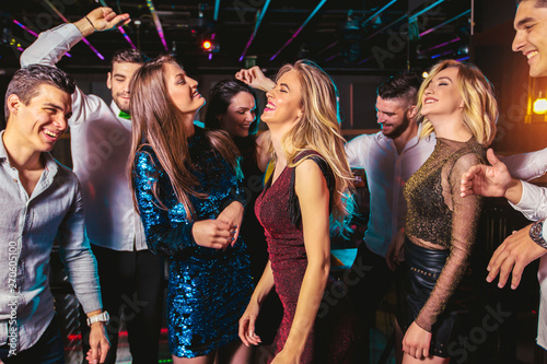 Młodzi szczęśliwi ludzie tańczą w klubie. Koncepcja życia nocnego i dyskoteki.