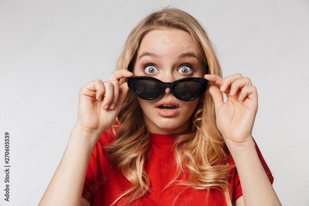 Beautiful woman posing isolated over white wall background wearing sunglasses. Beautiful woman posing isolated over white wall background wearing sunglasses.