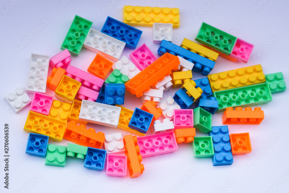 Multicoloured plastic construction blocks or bricks toy on white background Multicoloured plastic construction blocks or bricks toy on white background