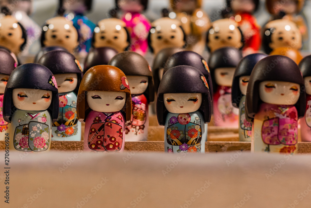 Close up macro shot of traditional asiatic miniature dolls. Oriental souvenirs, mass produced for international export and trade. Multitude, population and community concept. 