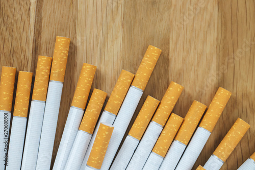 image of several commercially made cigarettes. pile cigarette on wooden. or Non smoking campaign concept  tobacco. top view.