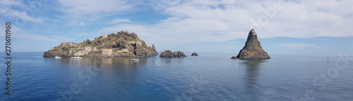 Aci Trezza panoramic view of cyclopean coastline, famous rocks and island in blue sea and sky of Sicily photo