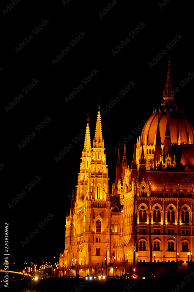 Budapest Hungary, 05.29.2019 Hungarian Parliament Building on the banks of the Danube River. night Budapest, glowing in gold. facade and roof of an old building