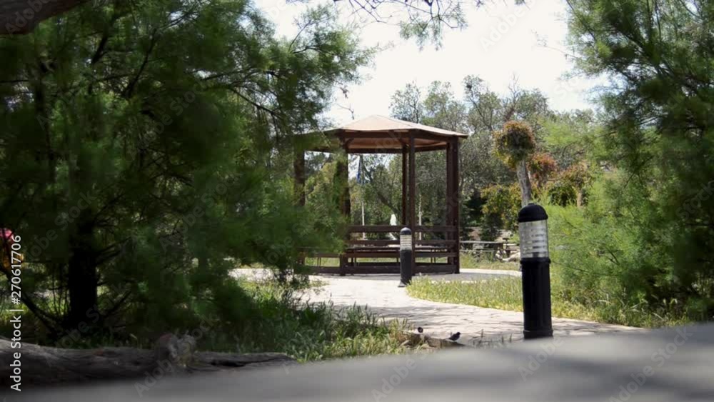 Enjoying day in the nature - scene from the park and gazebo with fountain water surounded by trees Enjoying day in the nature - scene from the park and gazebo with fountain water surounded by trees