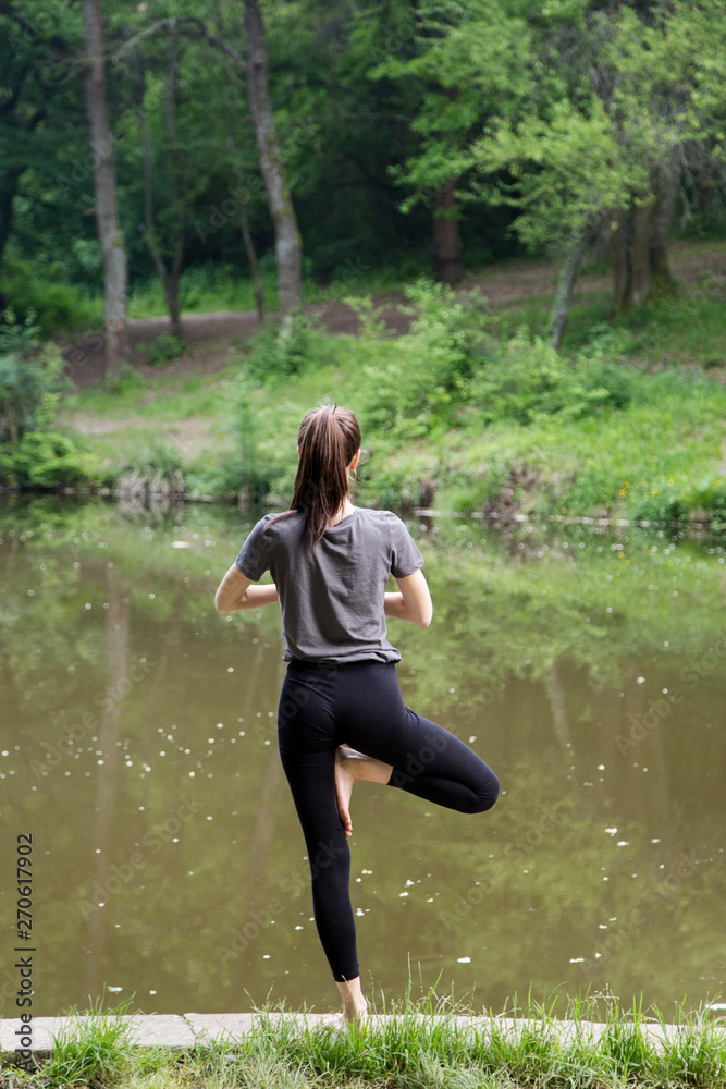 Beautiful woman meditating by the water