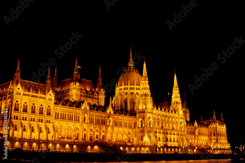 Budapest Hungary, 05.29.2019 Hungarian Parliament Building on the banks of the Danube River. night Budapest, glowing in gold. facade and roof of an old building © Yuliia