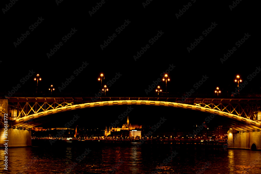 Naklejka premium Budapest Hungary, 05.29.2019 luminous bridge Magrid across the Danube River. night Budapest glowing in gold