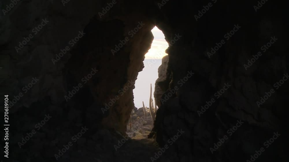 Wide low-angle still shot of Uyuni Salt Flats through a vertical rock hole in Cactus Island, Bolivia Wide low-angle still shot of Uyuni Salt Flats through a vertical rock hole in Cactus Island, Bolivia