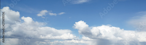 Blue sky in the soft white clouds. Natural cloudscape background, texture. Wide Horizontal Wallpaper