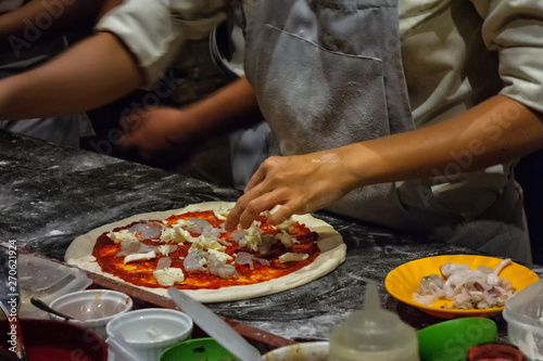 ピザ作り。 イタリンピッツァを調理するシェフ。マスタークラスで 学ぶ。 自家製ピザを準備する。