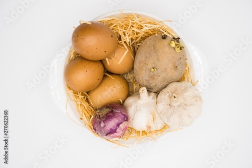 mix of egg potato onion and garlic on the nest with white background.
