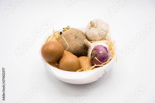 mix of egg potato onion and garlic on the nest with white background.